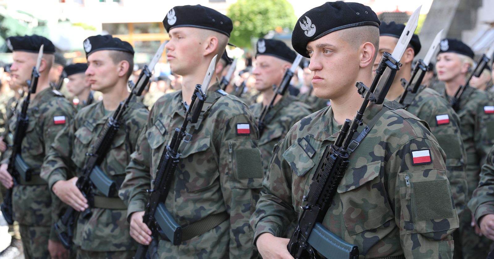 Polscy żołnierze w szyku z karabinkami z bagnetami podczas uroczystości przysięgi wojskowej.