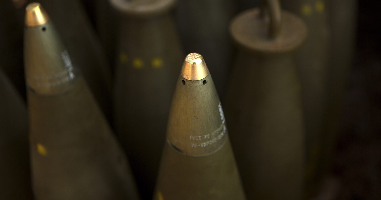Zbliżenie pocisków artyleryjskich kalibru 155 mm ustawionych pionowo przed załadowaniem