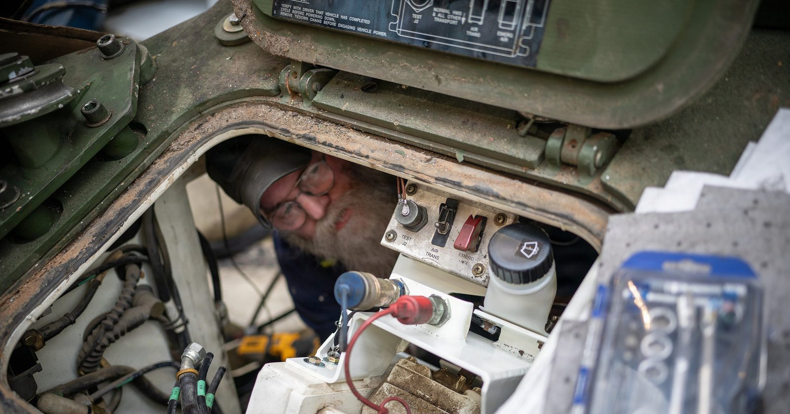 Mechanik serwisuje instalacje we wnętrzu przedziału transportera opancerzonego Stryker